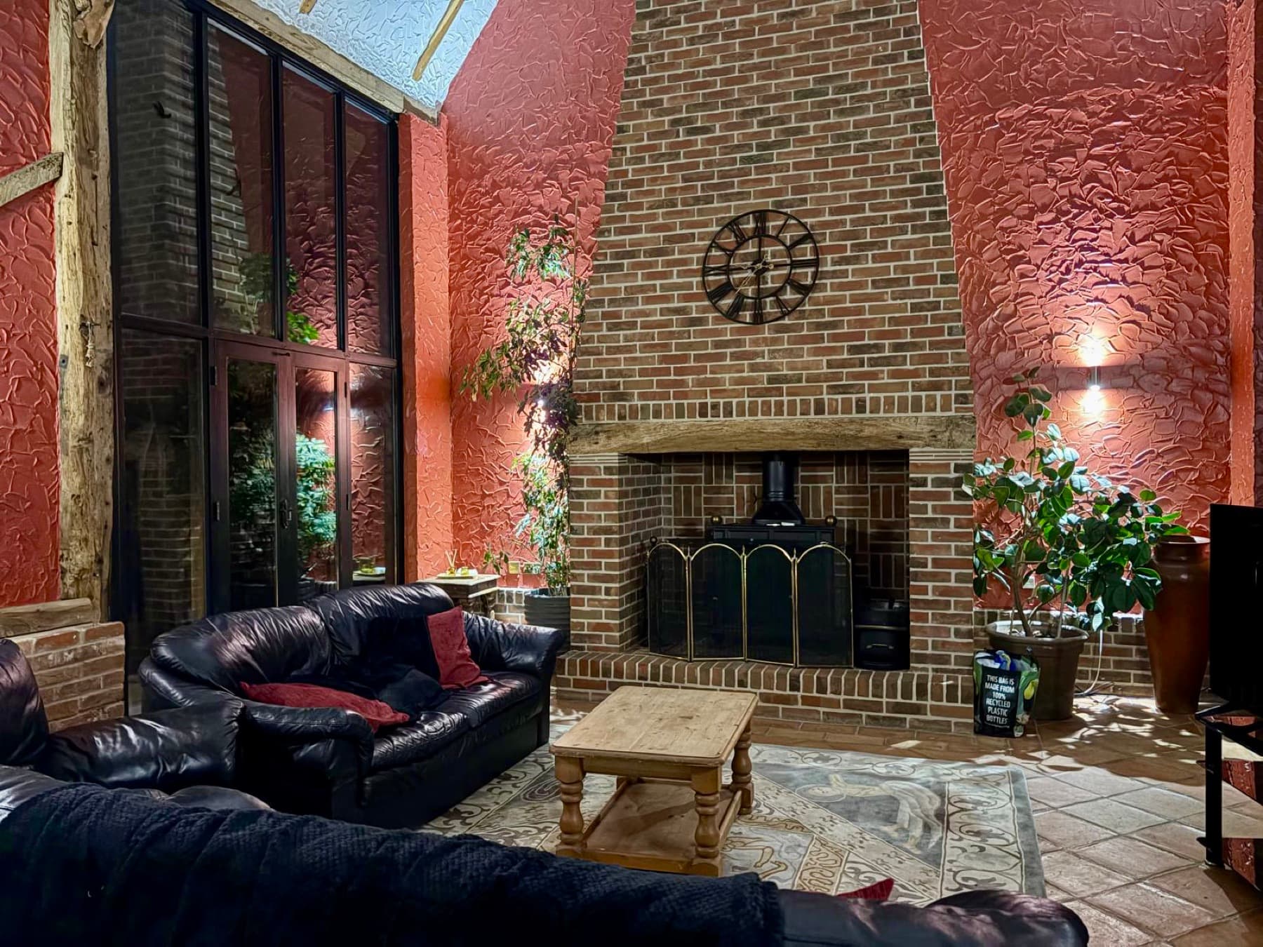 Double-height lounge with grand brick fireplace